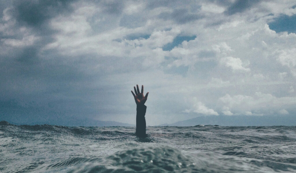 Hand die aus dem Meer streckt